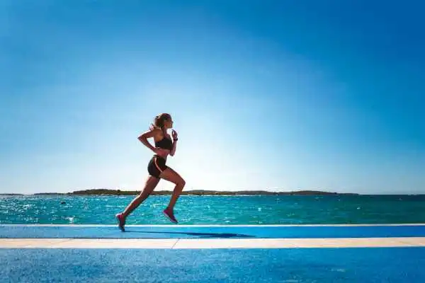 Woman running showing strong leg muscle Oxshott